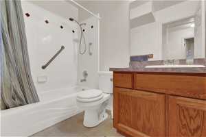 Full bathroom with shower / bath combo with shower curtain, vanity, toilet, and tile flooring