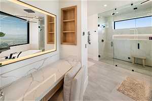 Level 1 Bathroom: Primary bathroom with vanity area, lighted mirror shelving and cabinet space.