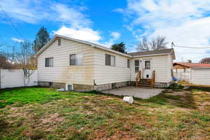 Rear view of house with a patio area and a lawn