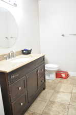 Bathroom with tile flooring, toilet, and vanity