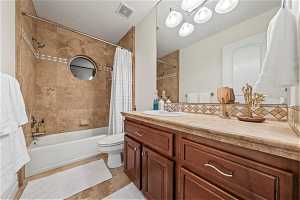 Upstairs Full bathroom with shower / bath combo with shower curtain, toilet, vanity, and tile floors