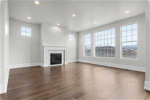 Unfurnished living room with hardwood / wood-style floors and a tile fireplace