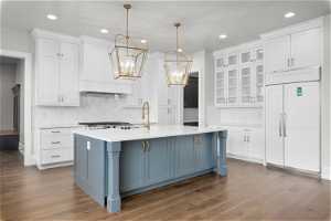 Kitchen featuring tasteful backsplash, pendant lighting, and white cabinetry