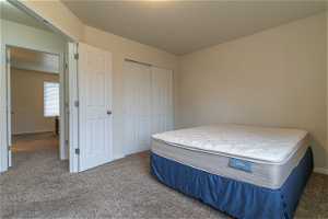 Bedroom featuring dark colored carpet and a closet