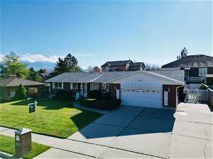 Ranch-style home with a garage and a front lawn.  RV, trailer, boat parking