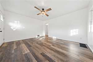 Spare room with dark hardwood / wood-style floors, ceiling fan, and a wealth of natural light