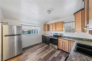 Kitchen featuring a wealth of natural light, dark hardwood / wood-style floors, appliances with stainless steel finishes, and backsplash