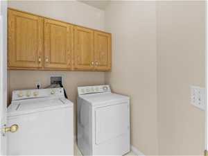 Laundry room with washer hookup, independent washer and dryer, and cabinets.