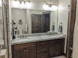 Bathroom with double vanity, toilet, and tile flooring