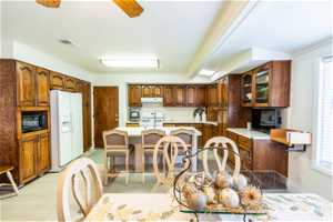 Kitchen featuring a center island, white appliances, light hardwood / wood-style flooring, ceiling fan, and exhaust hood