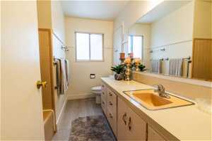 Full bathroom with vanity with extensive cabinet space, toilet, and shower / tub combination