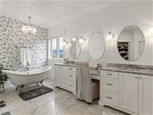 Bathroom with tile floors, double sink, vanity with extensive cabinet space, and a washtub