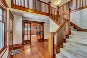 Entrance foyer with a wealth of natural light, a high ceiling, french doors, and hardwood / wood-style flooring
