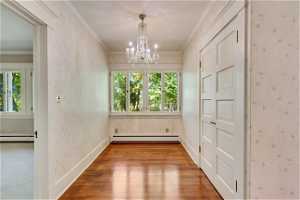 Secondary dining/prep area, baseboard heating, plenty of natural light, and an inviting chandelier