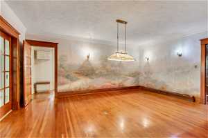 Dining room with Hand-painted murals of local mountains featuring ornamental molding and light hardwood / wood-style floors