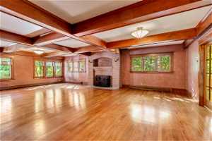 Unfurnished living room featuring light hardwood / wood-style flooring, a wealth of natural light, and a fireplace