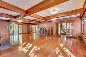 Spare room with coffered ceiling, light hardwood / wood-style flooring, french doors, and beamed ceiling