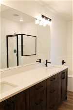 Bathroom featuring vanity with extensive cabinet space, double sink, and hardwood / wood-style flooring