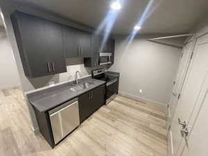 Kitchen featuring appliances with stainless steel finishes, sink, and light hardwood / wood-style floors