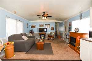 Living room featuring ceiling fan, light carpet, and vaulted ceiling