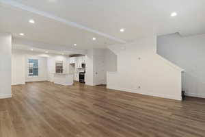 Unfurnished living room with dark wood-type flooring and sink