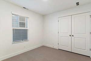 Unfurnished bedroom featuring light colored carpet and a closet