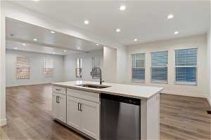 Kitchen with sink, dishwasher, light hardwood / wood-style floors, and white cabinets