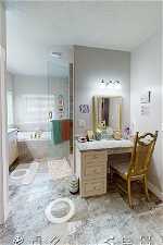 EXAMPLE ONLY - Bathroom featuring independent shower and bath, vanity, a textured ceiling, and tile floors