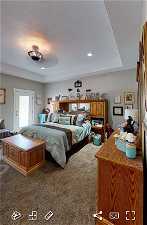 EXAMPLE ONLY - Bedroom with a tray ceiling, ceiling fan, and dark colored carpet