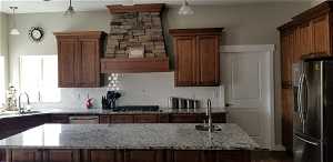 EXAMPLE ONLY - Kitchen featuring sink, hanging light fixtures, tasteful backsplash, and stainless steel appliances