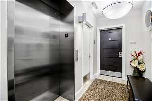 Foyer with elevator and light tile floors