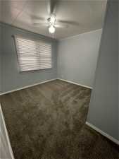 Unfurnished room featuring ceiling fan and carpet flooring