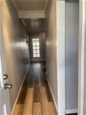 Corridor with crown molding and light hardwood / wood-style floors