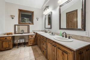 Bathroom with lofted ceiling, tile floors, and double sink vanity