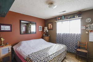 Tiled bedroom featuring a textured ceiling