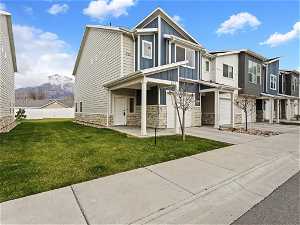 END UNIT #7. Multi unit property featuring a garage, a front lawn, and a mountain view
