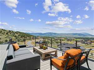 Deck featuring an outdoor living space, with amazing golf course, mountain, valley and lake views!