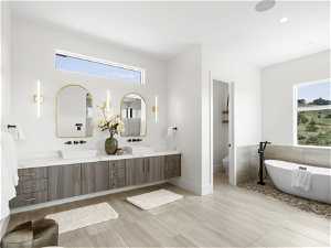 Primary owner onsuite with oversized vanity, plenty of natural light, double sink, and tile flooring