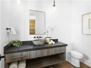 Bathroom with toilet, hardwood / wood-style flooring, and vanity