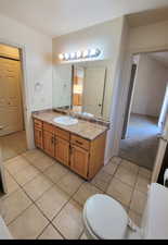 Bathroom featuring toilet, tile floors, a textured ceiling, and vanity