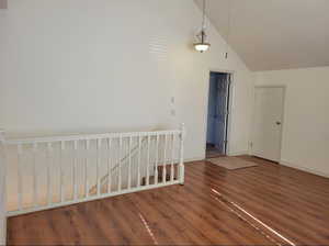 Unfurnished room with dark hardwood / wood-style flooring and high vaulted ceiling