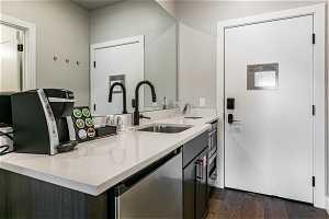 Kitchen with dark hardwood / wood-style floors, dishwasher, sink, and dark brown cabinetry