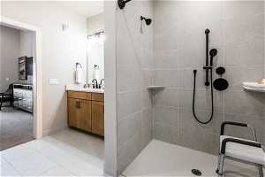 Bathroom featuring vanity, tile floors, and a tile shower