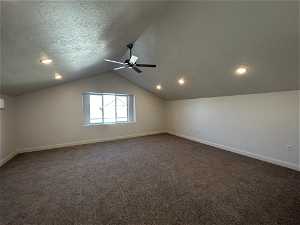 Bonus room featuring ceiling fan, a textured ceiling, carpet flooring, and vaulted ceiling