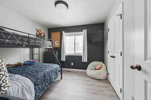 Bedroom with light wood-type flooring and a closet