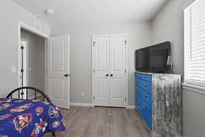 Bedroom featuring light wood-type flooring and a closet