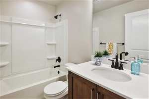 Full bathroom with toilet,  shower combination, and vanity