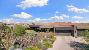 Pueblo-style house with a garage and a mountain view