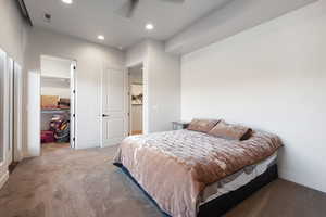 Carpeted bedroom featuring a spacious closet, ceiling fan, and a closet