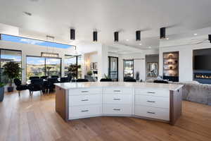 Kitchen with ceiling fan, a center island, white cabinets, and decorative light fixtures